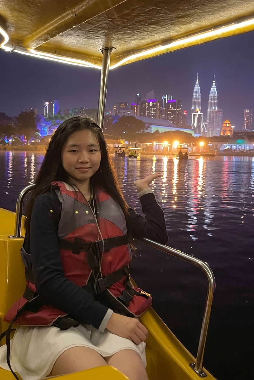 Guest enjoying scenic night boat ride with illuminated Kuala Lumpur skyline